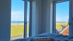 A bed with a pillow labeled "relax." - Baltic Sea vacation apartment Surfside - sea view from every window (Schönberg (Holstein))
