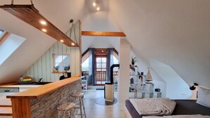A modern loft apartment with a kitchen, dining area, and living space. - Vacation apartment Ackerblick on a beautiful vacation farm near the Baltic Sea (Schwartbuck)