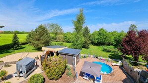 A backyard with a swimming pool, a covered outdoor seating area, and a small shed. - Vacation apartment Ackerblick on a beautiful vacation farm near the Baltic Sea (Schwartbuck)