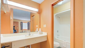 A bathroom with a white sink, mirror, and a bathtub. - Hotel O Deluxe Inn Kingstree Sc Hwy 52 (Kingstree)