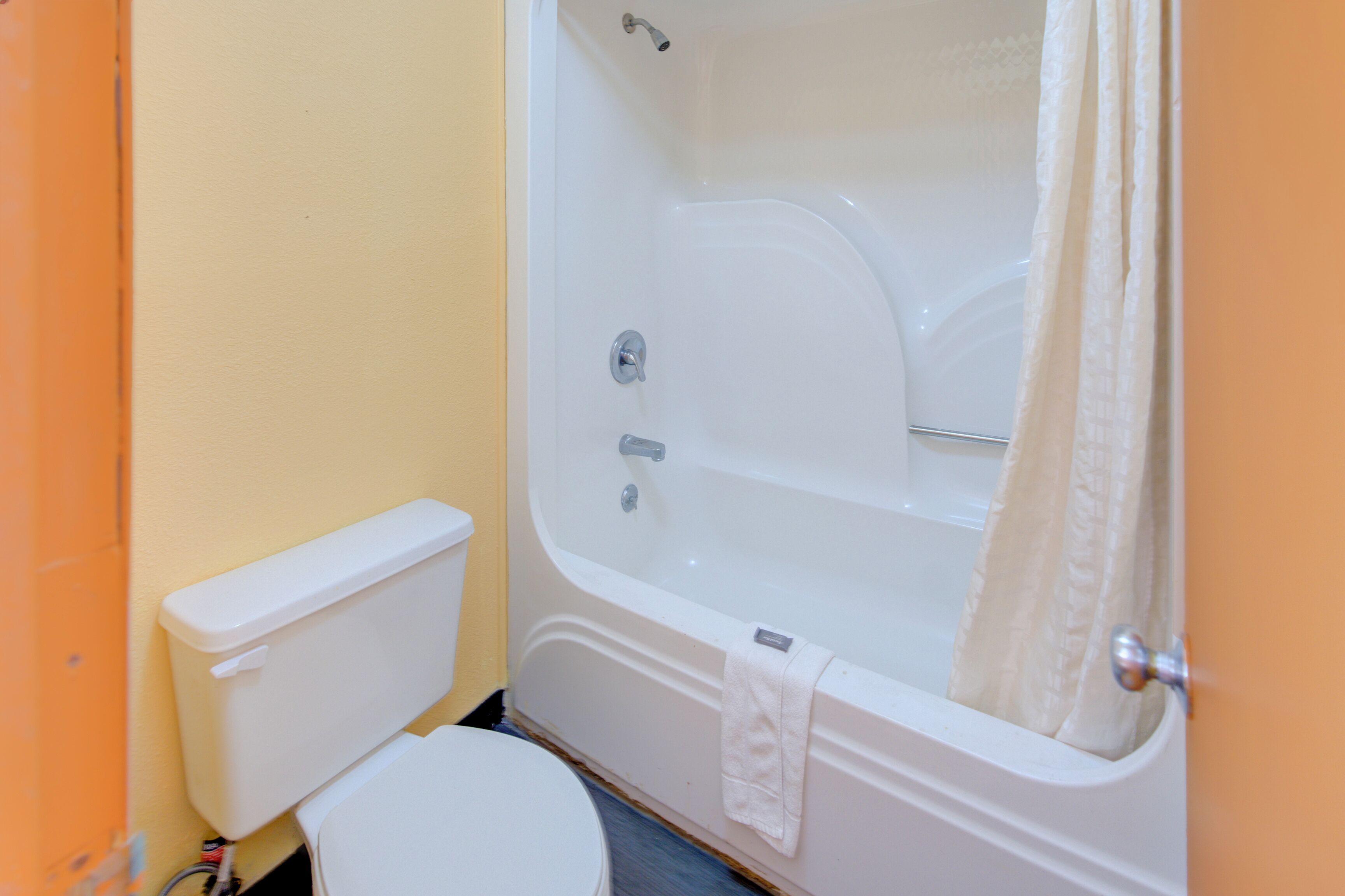 Un baño con bañera, inodoro y cortina de ducha.