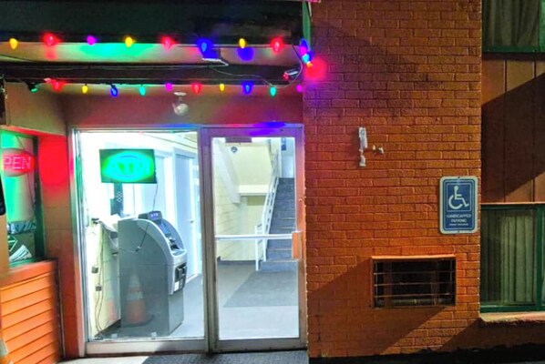 A building entrance with a wheelchair-accessible sign, a ramp, and a parking meter. - Capital O Pleasant Motel Grand Rapids Mi (Grand Rapids)