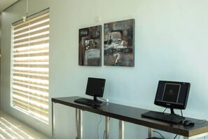 A room with a desk, two monitors, and artwork on the wall. - Casablanca Suites Near Airport (Legaspi)