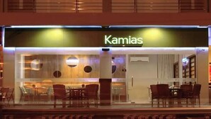 Ein Hotel namens "Kamias" mit modernem Innenraum, der durch die Glasfassade sichtbar ist.