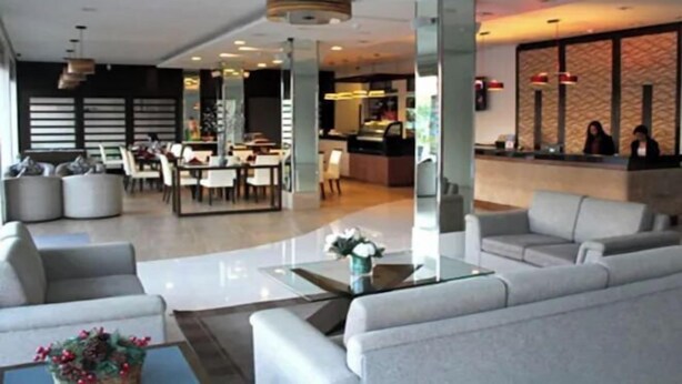 Eine moderne Hotelhalle mit Rezeption, Sitzgelegenheiten und Essbereich.
