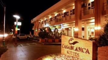 Entrada de un hotel con un letrero que dice 'CASABLANCA SUITES' y una fachada de edificio bien iluminada.