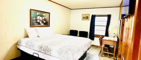 A bedroom with a bed, a desk, and a chair.