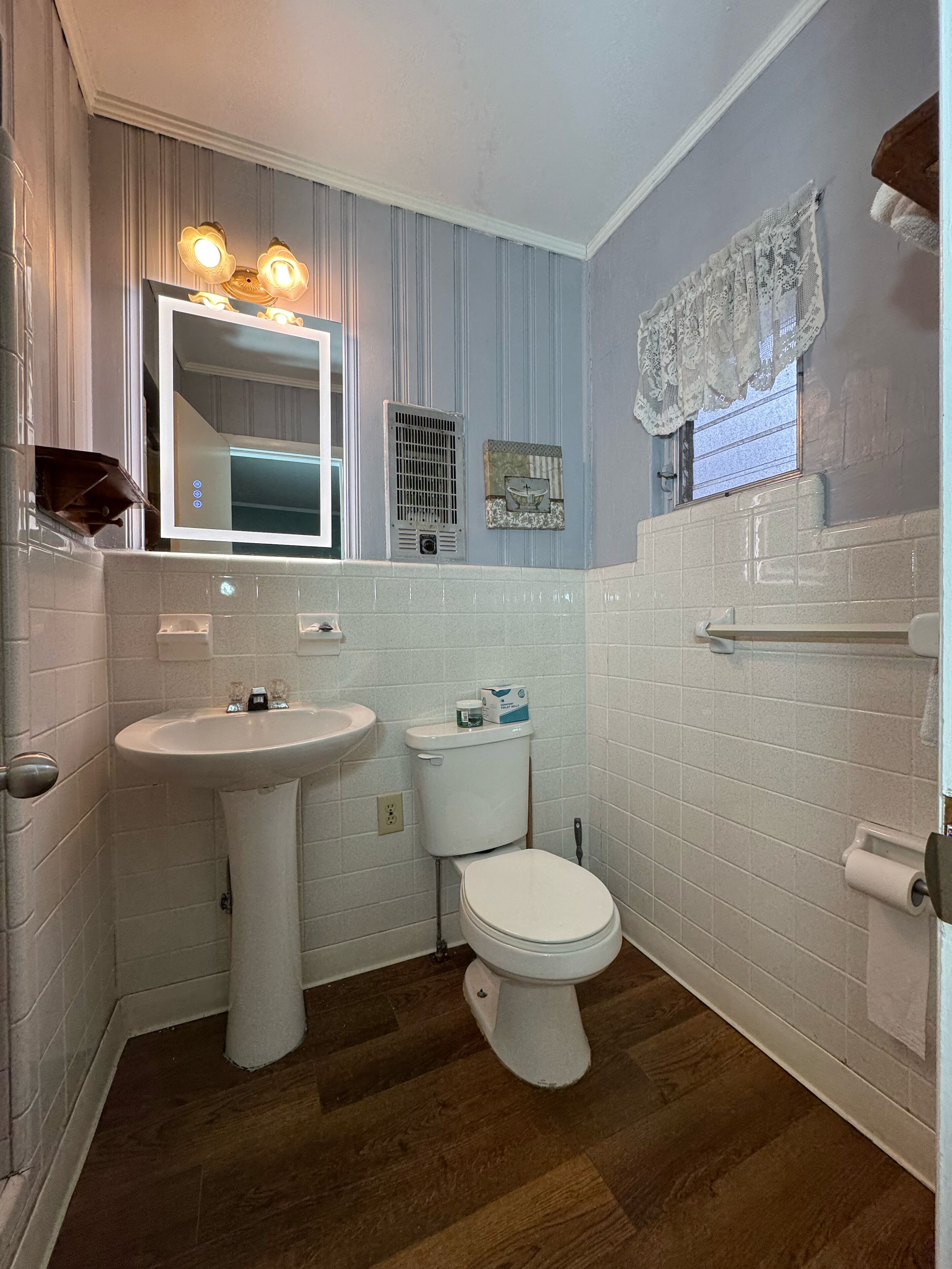 Ein Badezimmer mit Waschbecken, Toilette und Spiegel.