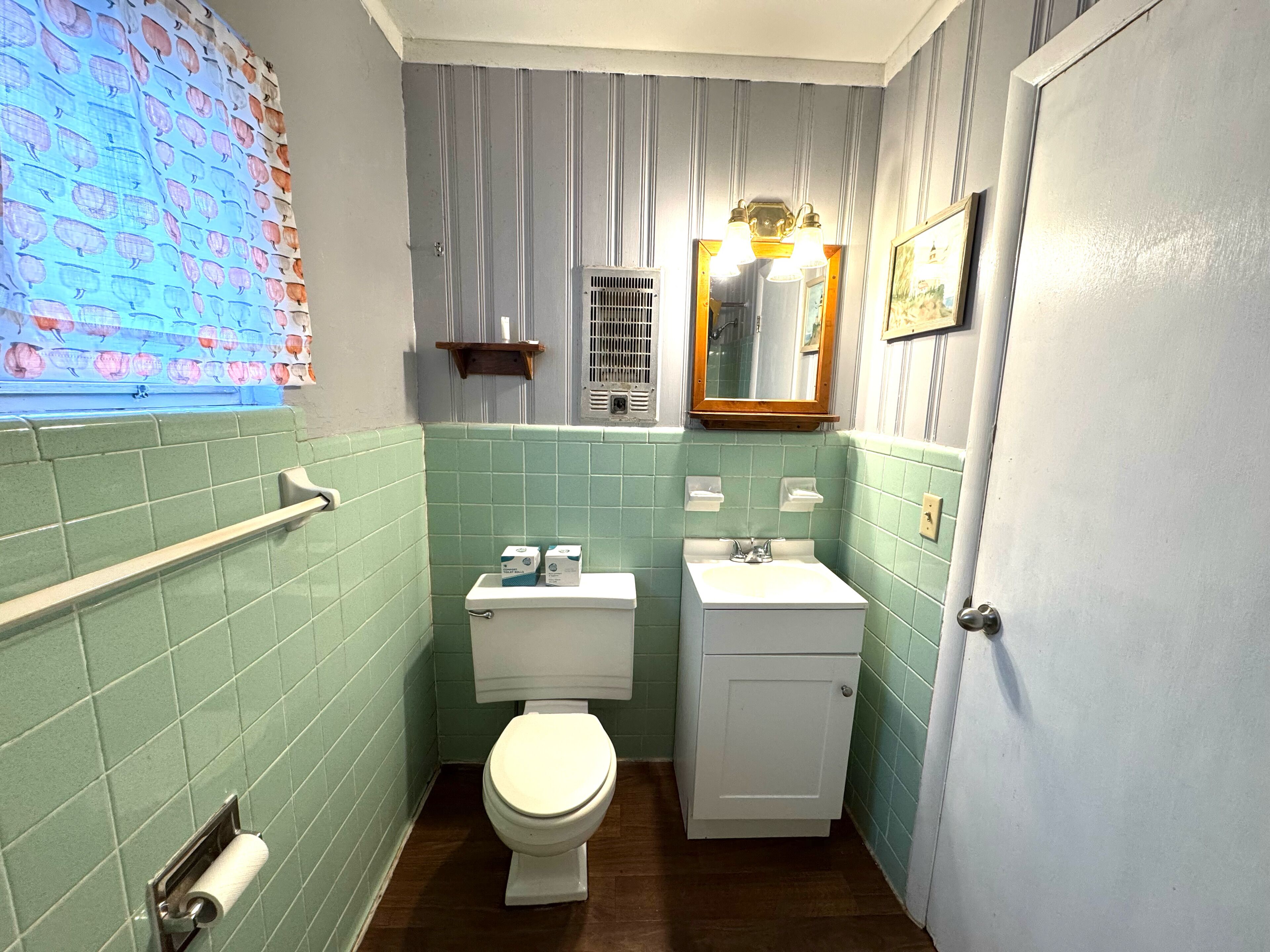 Un baño con inodoro, lavamanos y espejo.