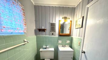 Un baño con inodoro, lavamanos y espejo.