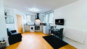 A compact living space with a kitchenette, a dining area, and a seating area. - Chic studio, sleeps 2, free parking (Pudsey)