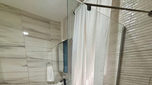 A modern bathroom with a glass shower enclosure, a toilet, a sink, and a mirror. - Charming studio in the Heart of Sosua, Facing the pool & at 2 min from the Beach (Sosúa)