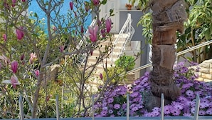 A view of a balcony with a railing, a staircase, and a body of water in the background. - Apartments Bilić Trogir (Trogir)