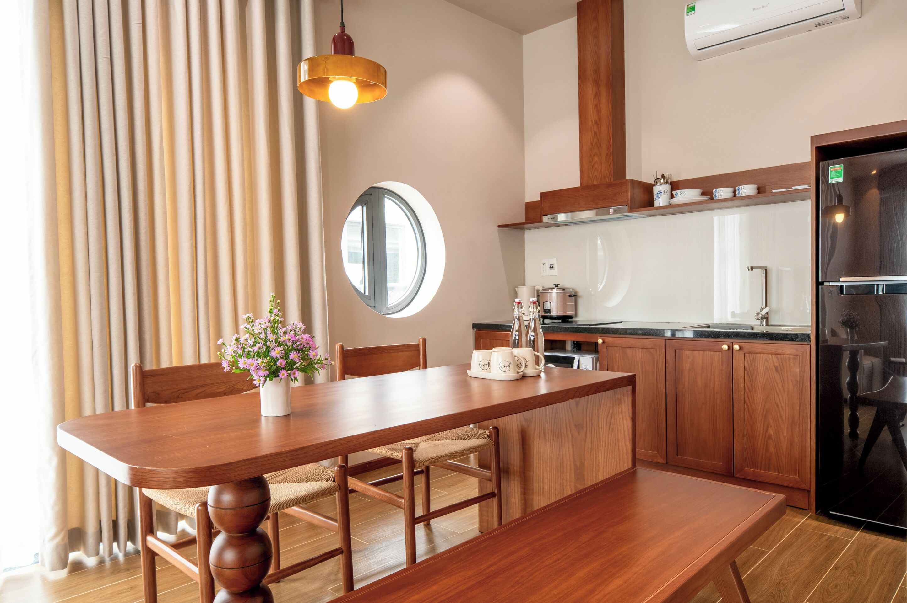 A modern kitchen with wooden cabinets, a built-in oven, and a black refrigerator.