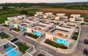 A modern residential complex with multiple houses, each featuring a swimming pool and solar panels on the roof. - Stunning home in Tar with private swimming pool, can be inside or outside (Tar)