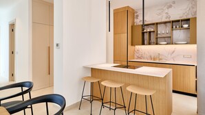 A modern kitchen with a central island, bar stools, wooden cabinets, and a backsplash with a floral pattern. - Awesome home in Tar with private swimming pool, can be inside or outside (Tar)