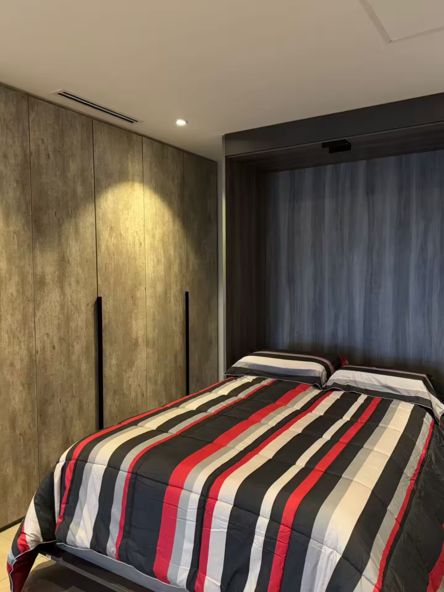 Une chambre à coucher avec un lit, une armoire et une fenêtre avec des rideaux.