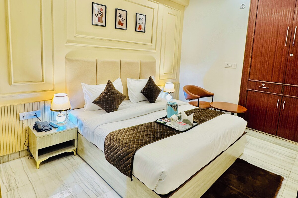 A hotel room with a bed, bedside table, lamp, and a wardrobe.