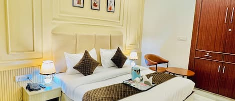 A hotel room with a bed, bedside table, lamp, and a wardrobe.