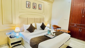 A hotel room with a bed, bedside table, lamp, and a wardrobe. - Hotel Classic Crowne (New Delhi)