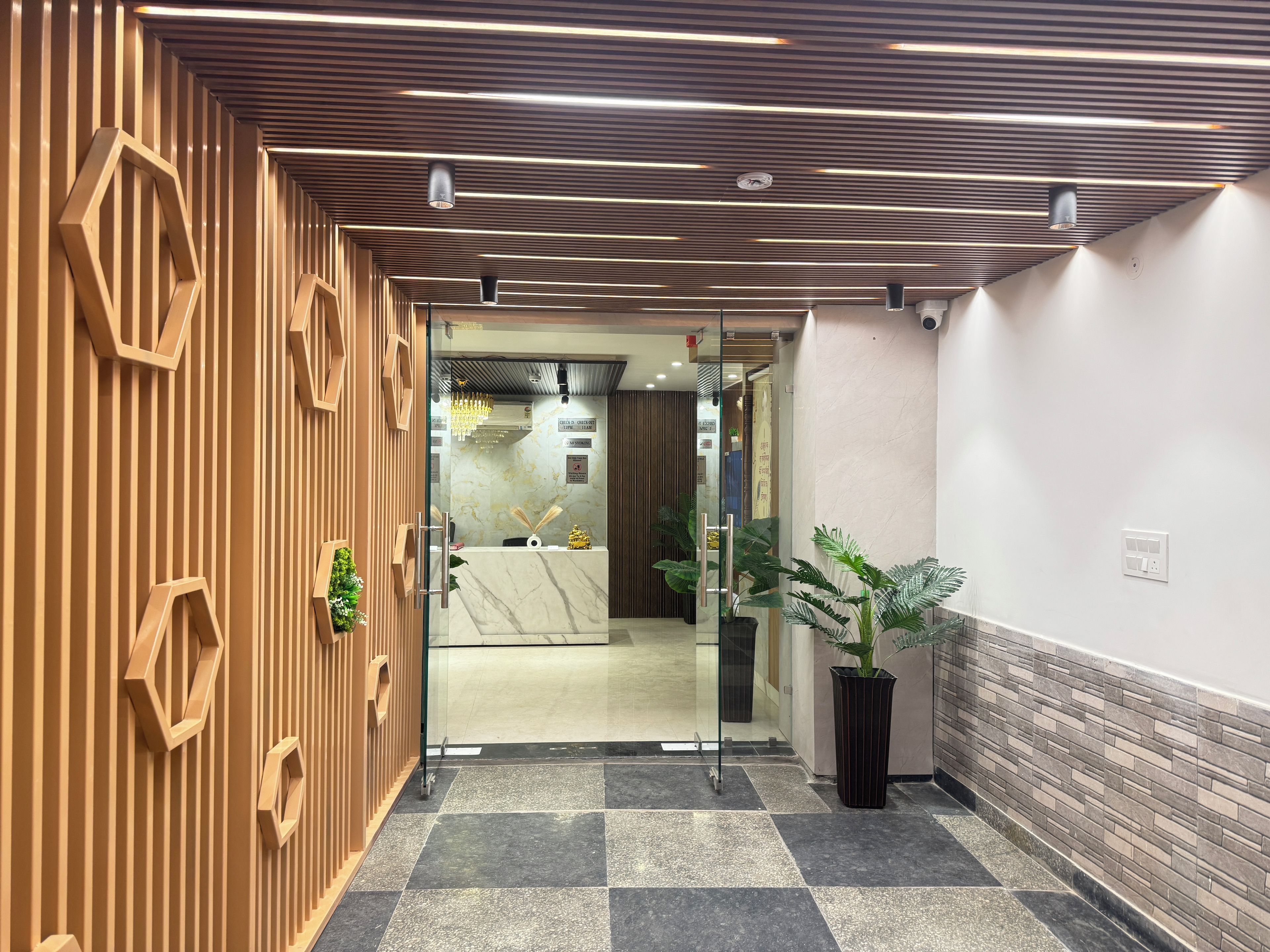 A reception area with a modern design, featuring a reception desk, glass doors, and a check-in counter.
