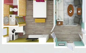 Habitació d'hotel moderna amb llit, sofà, taula petita, escriptori i bany amb vàter i rentapans.