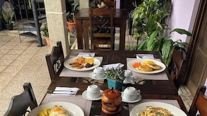 Una mesa con platos de comida, vasos y cubiertos.