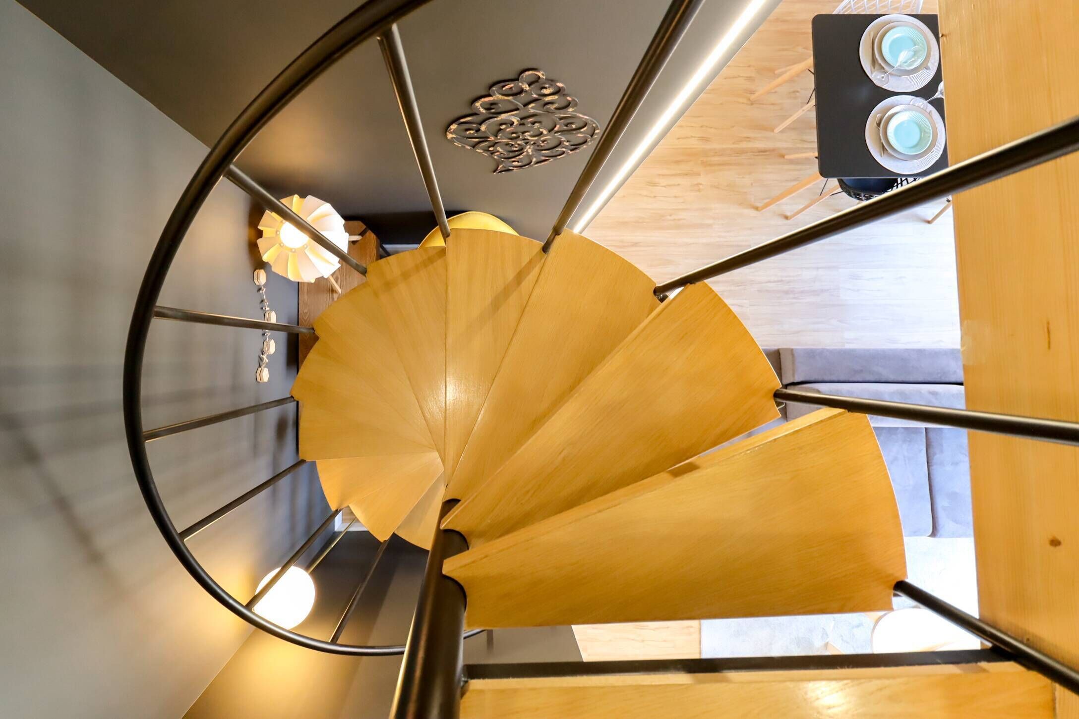Una escalera de caracol con detalles de madera y barandillas de metal.