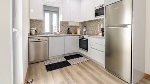 A modern kitchen with white cabinets, stainless steel appliances, and a granite countertop.