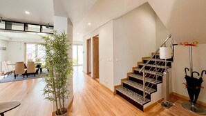 Ein geräumiger Wohnbereich mit Treppe, Essbereich und einem Blumentopf.