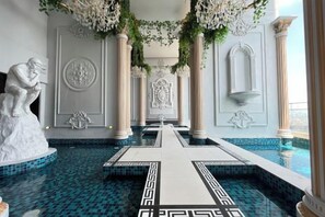 A hotel lobby with a central pool, columns, and a statue. - Arte Cheras by Awesomestay (Kuala Lumpur)