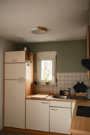 Une cuisine de taille réduite, dotée d’une fenêtre, d’un évier, d’une cuisinière et d’un lave-vaisselle.
