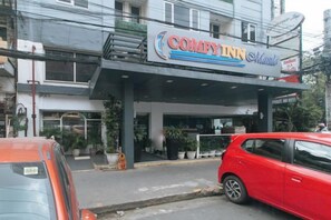 A building with a sign that reads 'COMFYINN Manila' and a covered entrance. - Comfy Inn Manila Kalaw by RedDoorz (Manila)