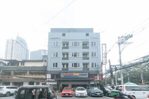 A multi-story building with a ground-level commercial space, including a hotel and a restaurant. - Comfy Inn Manila Kalaw by RedDoorz (Manila)