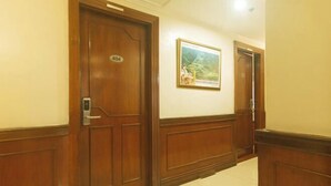 Un pasillo con puertas de madera, un cuadro en la pared y el número 404 en una puerta.