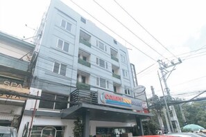 A multi-story building with a visible ground-floor commercial space, including a restaurant with a prominent sign. - Comfy Inn Manila Kalaw by RedDoorz (Manila)