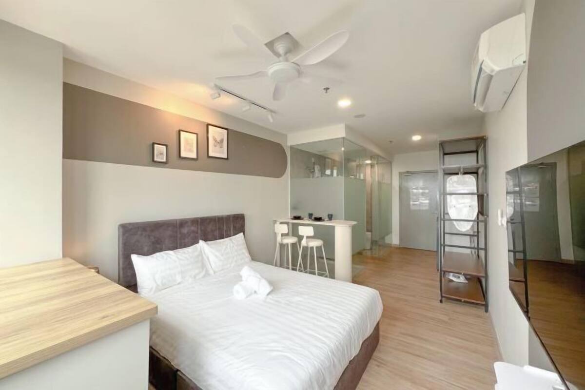 A modern hotel room with a bed, a desk, and a chair.