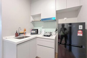 A compact kitchen with white cabinets, a stainless steel refrigerator, a microwave, and a kettle. - Riveria City Kuala Lumpur Sentral by Archos (Kuala Lumpur)