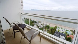 Varanda com vista para o mar e uma paisagem urbana ao longe.