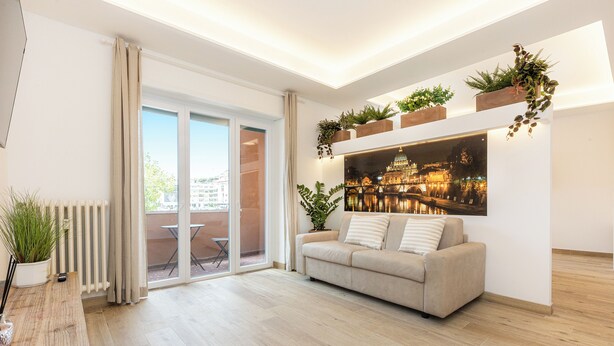 A modern living room with a sofa, a coffee table, and potted plants. - Spacious BnB with 3 rooms and kitchen, a few steps from St. Peter's (Roma)