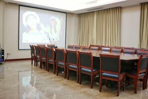 A conference room with a long table and chairs, a projector screen, and a presentation visible. - Laos Guiting Hunan Grand Hotel (Free Airport Transfer with Reservation） (Vientiane)