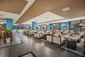 A hotel lobby with seating areas, a reception desk, and a large screen displaying content. - Laos Guiting Hunan Grand Hotel (Free Airport Transfer with Reservation） (Vientiane)