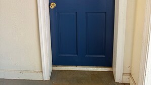 Uma porta azul escura com o número 2, detalhes brancos e uma fechadura.