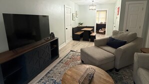 Uma sala de estar com televisão, sofá e mesa de centro.