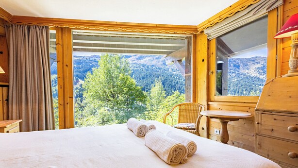 Une pièce comprenant un lit, une commode en bois, une chaise et une table.