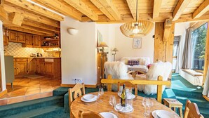 Un intérieur en bois comprenant un coin repas, une cuisine et un espace de vie.