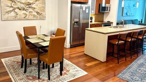 A modern kitchen with a central island, stainless steel appliances, and wooden cabinets. - Luxury 2BR/2BA Channelside Condo- Pool, Sauna, Gym + Balcony (Tampa)