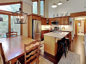 A modern kitchen with wooden cabinets, stainless steel appliances, and a large island with bar stools.
