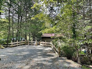 A gravel path leading to a wooden cabin surrounded by trees. - Somewhere by Taylor Made Deep Creek (Oakland)