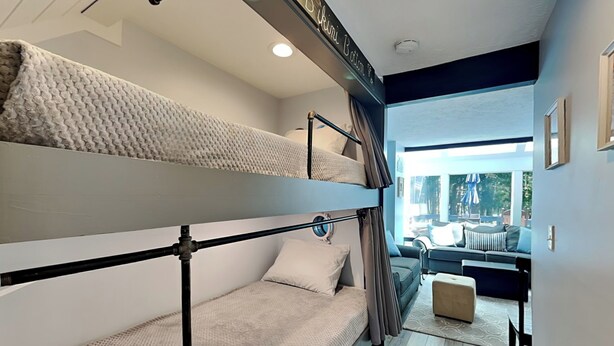 A bunk bed room with a view of a living area and outdoor seating. - Arrowhead Village 13 by Taylor Made Deep Creek (Oakland)